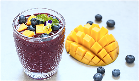 purple smoothie with chopped mango and blueberries