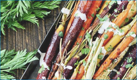 cooked rainbow carrots with chopped cilantro and yogurt sauce